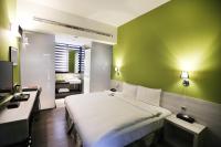 a bedroom with a large bed and a green wall at Miller Inn in Taichung