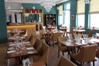 uma sala de jantar com mesas e cadeiras de madeira em Yarrow Hotel em Broadstairs