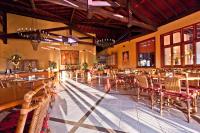 a restaurant with tables and chairs in a room at Canto da Floresta Ecoresort in Amparo