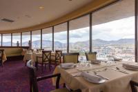 Un restaurante con mesas y sillas y grandes ventanales. en Radisson Hotel Trinidad, en Puerto España