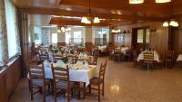 uma sala de jantar com mesas e cadeiras em um restaurante em Hubertushof em Trattenbach