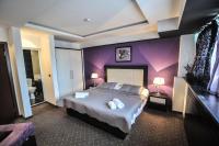 a bedroom with a large bed with purple walls at B&amp;B Rose in Vranje