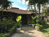 ein Haus mit Palmen und Pflanzen davor in der Unterkunft Amoreiras Hotel Pousada in Maresias