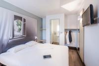 ブール・レ・ヴァロンスにあるB&amp;B HOTEL Valence Nordの白いベッドとテレビのある寝室