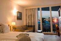 a hotel room with a bed and a large window at Hotel Cannes Montfleury in Cannes