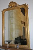 a large gold mirror sitting on a wooden table at Chambre d&#39;hôtes Au jardin de la Bachellerie in La Bachellerie