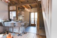 a kitchen with a bar in a room with wooden beams at HISSLA ALSACE CHIC&amp; COSY BARR Wine Route in Barr