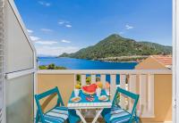 a table and chairs on a balcony with a view of the ocean at Apartments More in Sobra