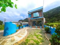 a house on top of a hill with blue walls at Blue Sea Romance B&amp;B in Green Island