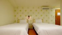 two beds in a small room with white sheets at Green Park Commercial Hotel in Tainan