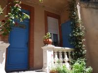 a house with a blue door and a vase on a porch at Les Loges des Chalets in Toulouse