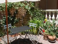 a table and chairs in a garden with plants at Les Loges des Chalets in Toulouse