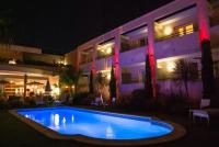 a swimming pool in front of a building at night at Logis Hôtel La Fauceille in Perpignan