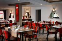 Hôtel Restaurant Le Colibri في Douvrin: غرفة طعام مع طاولات وكراسي حمراء