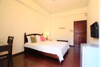 a bedroom with a bed and a flat screen tv at East of Love Homestay in Hualien City