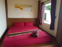 a pink bed with a pair of shoes sitting on it at Moonstone Studio in Haad Rin