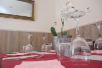 une table avec des verres à vin et une fleur dans un vase dans l'établissement Hostal Delgado, à Benabarre