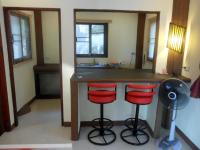 a kitchen with a counter and two red bar stools at Moonstone Studio in Haad Rin