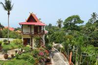 a house with a garden and flowers in front of it at Moonstone Studio in Haad Rin
