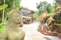 a statue of a woman standing next to a street at Moonstone Studio in Haad Rin