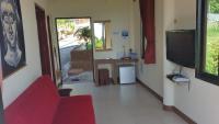 a living room with a red couch and a tv at Moonstone Studio in Haad Rin