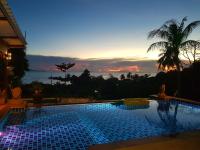 a swimming pool with a sunset in the background at Moonstone Studio in Haad Rin