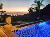 a swimming pool with a statue next to a resort at Moonstone Studio in Haad Rin