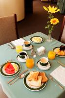 a table topped with plates of breakfast foods and orange juice at Hotel Diplomat in Cochabamba