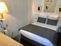 a hotel room with a bed and a table at Hôtel-Restaurant La Mascotte in La Baule