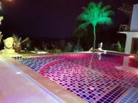 a swimming pool at night with pink and purple lights at Moonstone Studio in Haad Rin