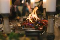 a plate of food on top of a table with flames at Original Sokos Hotel Vaakuna Rovaniemi in Rovaniemi