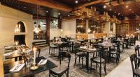 a restaurant with tables and chairs and a fireplace at Original Sokos Hotel Vaakuna Rovaniemi in Rovaniemi