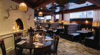 a restaurant with tables and chairs and a fireplace at Original Sokos Hotel Vaakuna Rovaniemi in Rovaniemi