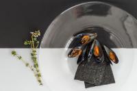 une assiette décorée d'un papillon à côté d'une plante dans l'établissement Kiss Beachfront Hotel & Restaurant, à Cervia