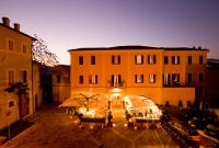 un edificio con mesas y sombrillas en un patio en Hotel Clitunno, en Spoleto