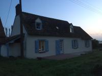 a small white house with blue windows on a field at Fleur House in Teloché