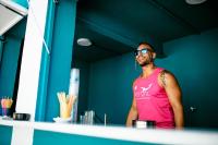 a man wearing a pink tank top standing in a room at Hotel Ritual Torremolinos- Adults Only in Torremolinos