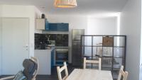 a kitchen with a table and chairs and a refrigerator at Les Halles 1 in La Rochelle
