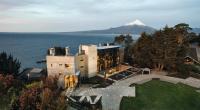 a building with a cross in front of a mountain at Hotel AWA in Puerto Varas