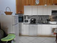 a kitchen with white cabinets and a sink and a refrigerator at Gite du Cret in Hotonnes