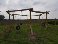an empty playground with swings in a field at Holiday home Het Zeugekot in Beveren