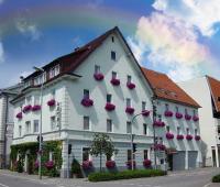 un gran edificio blanco con cajas de flores. en Hotel Rosengarten Tuttlingen, en Tuttlingen