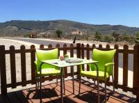 a table and two chairs sitting on a balcony at Complejo Pueblo Blanco in Olvera