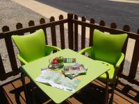 a green table and two chairs on a balcony at Complejo Pueblo Blanco in Olvera