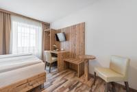 a bedroom with a bed and a desk and a table at City Rooms Wels - contactless check-in in Wels