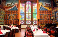 un restaurante con mesas, sillas y vidrieras en Hotel Golden Dome Iisalmi, en Iisalmi