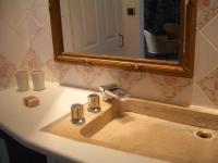 a bathroom sink with a mirror and a faucet at Le Prieuré des Sources in La Répara