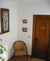 a room with a chair and a wooden door at El Perro de Paterna in Paterna de Rivera