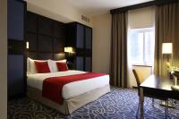 Una habitación de hotel con una cama grande y un escritorio. en The Eclipse Boutique Suites, en Abu Dabi