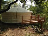 a yurt sitting under a tree with a bench at Le Mas Nomade in Callian